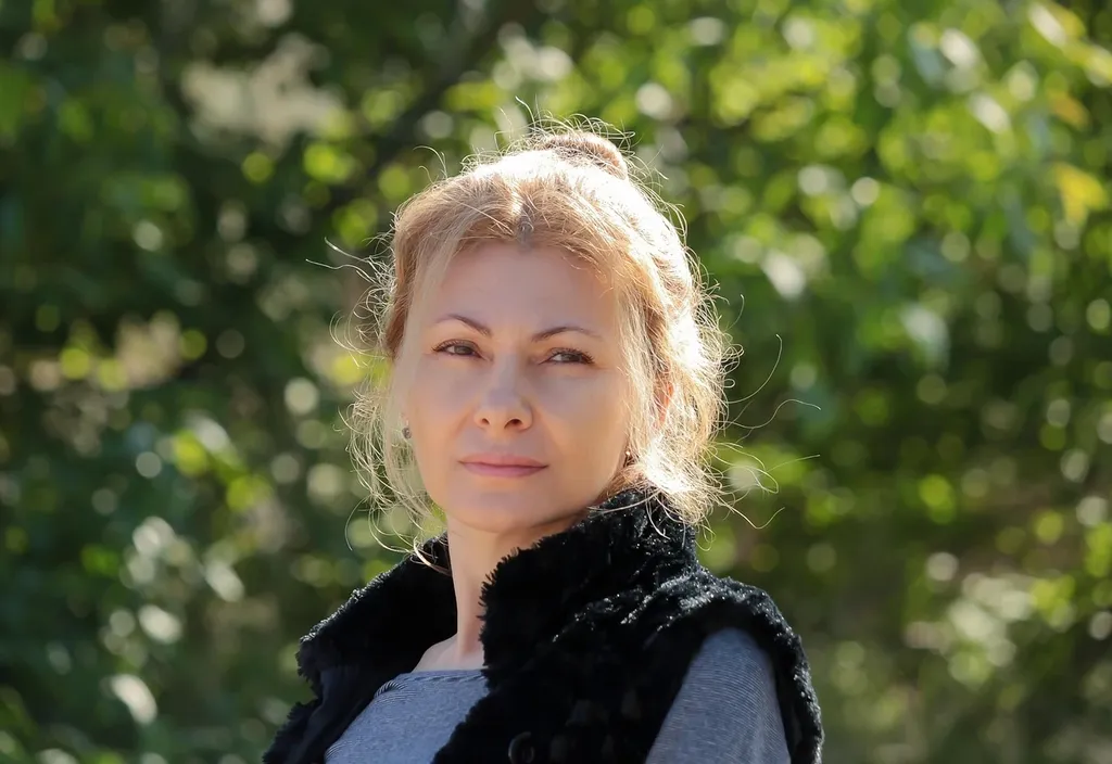 Porträt von Lena Wurzenberger vor einer städtischen Kulisse, Hauptfarbthema Rot.